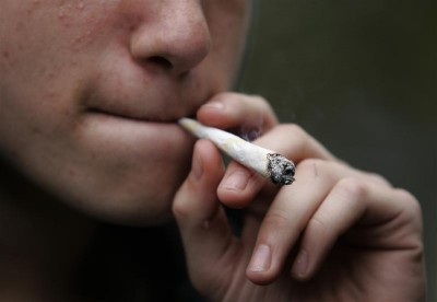 A young man smokes marijuana before the 10th annual Marijuana March in downtown Toronto