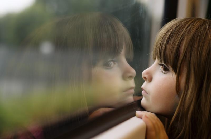 little-girl-looking-through-window